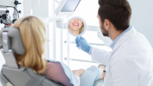 Dentista, dono de consultórios odontológicos, mostra à paciente o resultado do tratamento pago no modelo de cobrança recorrente.
