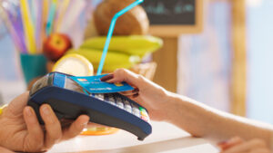 Cliente faz pagamento de compra aproximando o cartão da maquininha, utilizando o método de contactless.