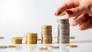 Empreendedora empilha moedas para abrir seu próprio negócio enquanto estuda sobre como empreender com pouco dinheiro